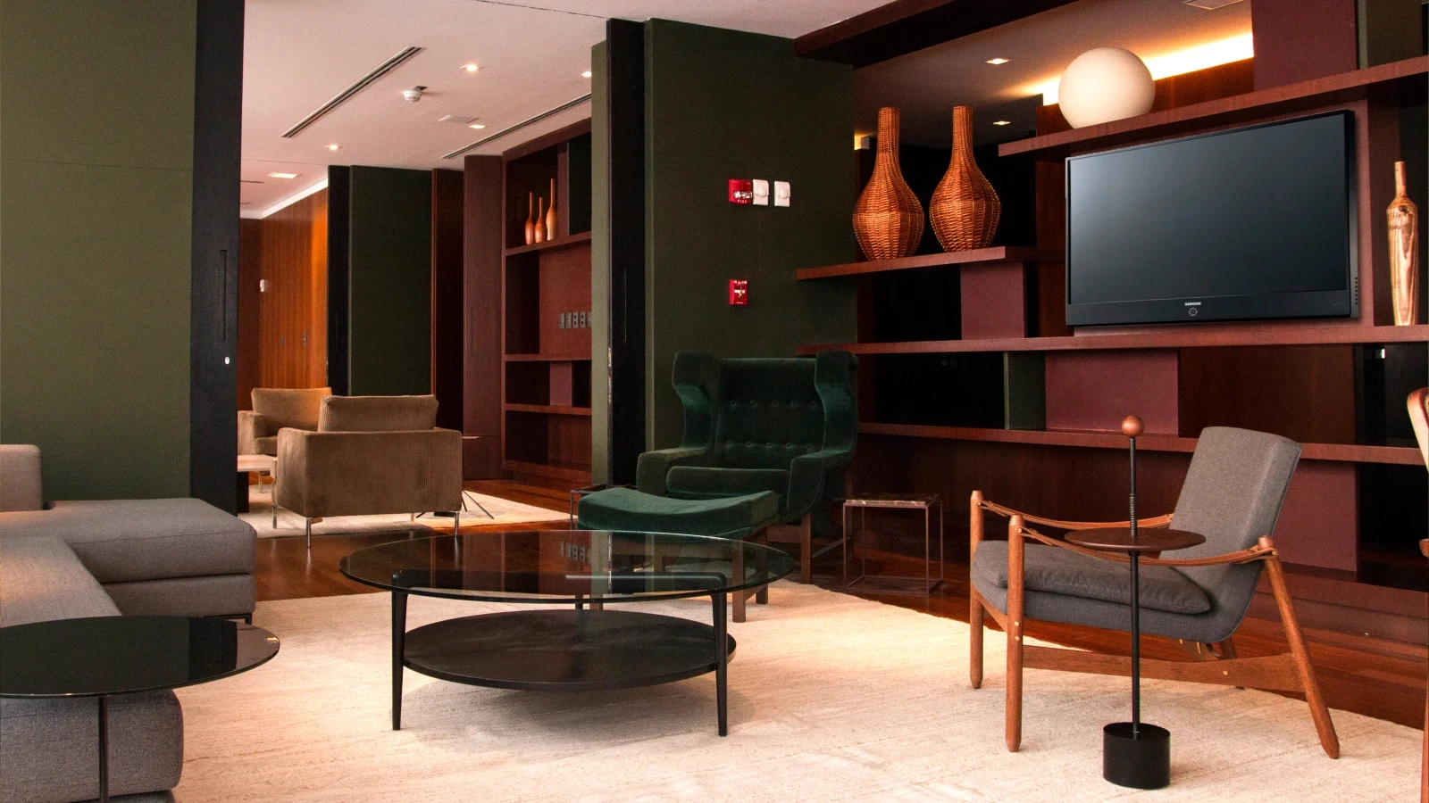 Vue du salon voyageur avec mobilier deign, bibliothèque et téléviseur