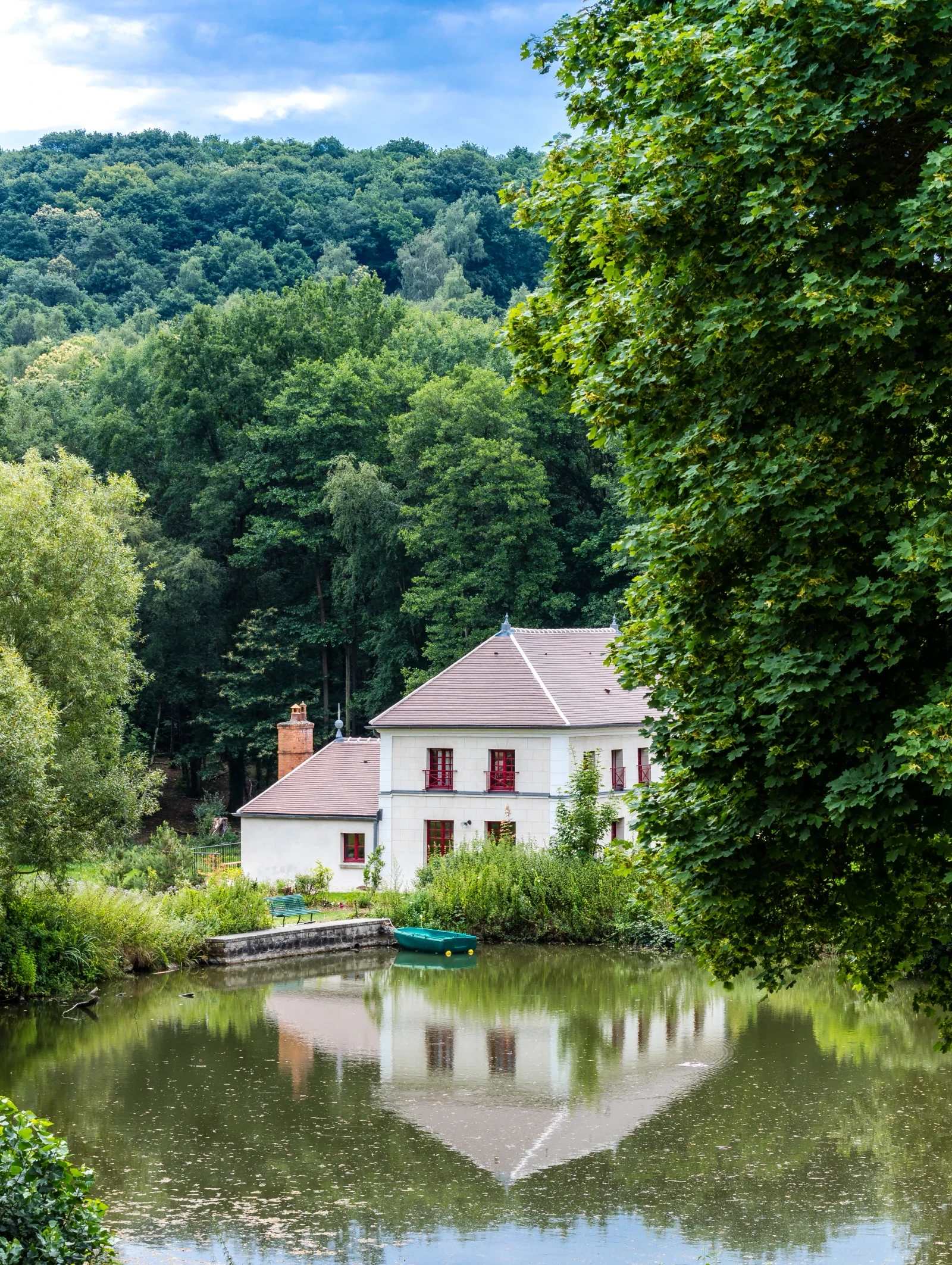 Maison de campagne en pleine forêt, lac en premier plan