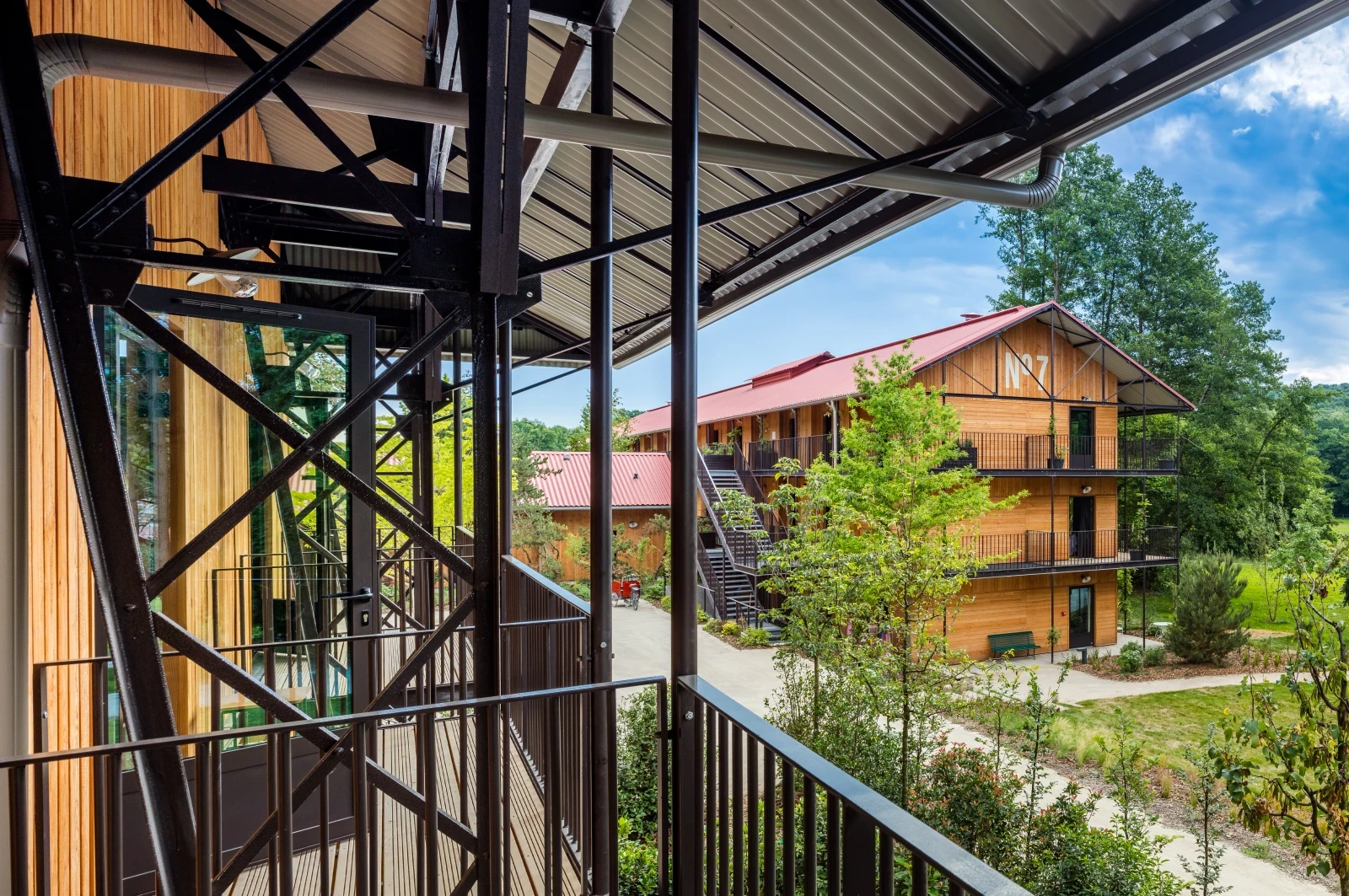 vue d'un balcon, structure métalliques, chalet entouré d'une forêt