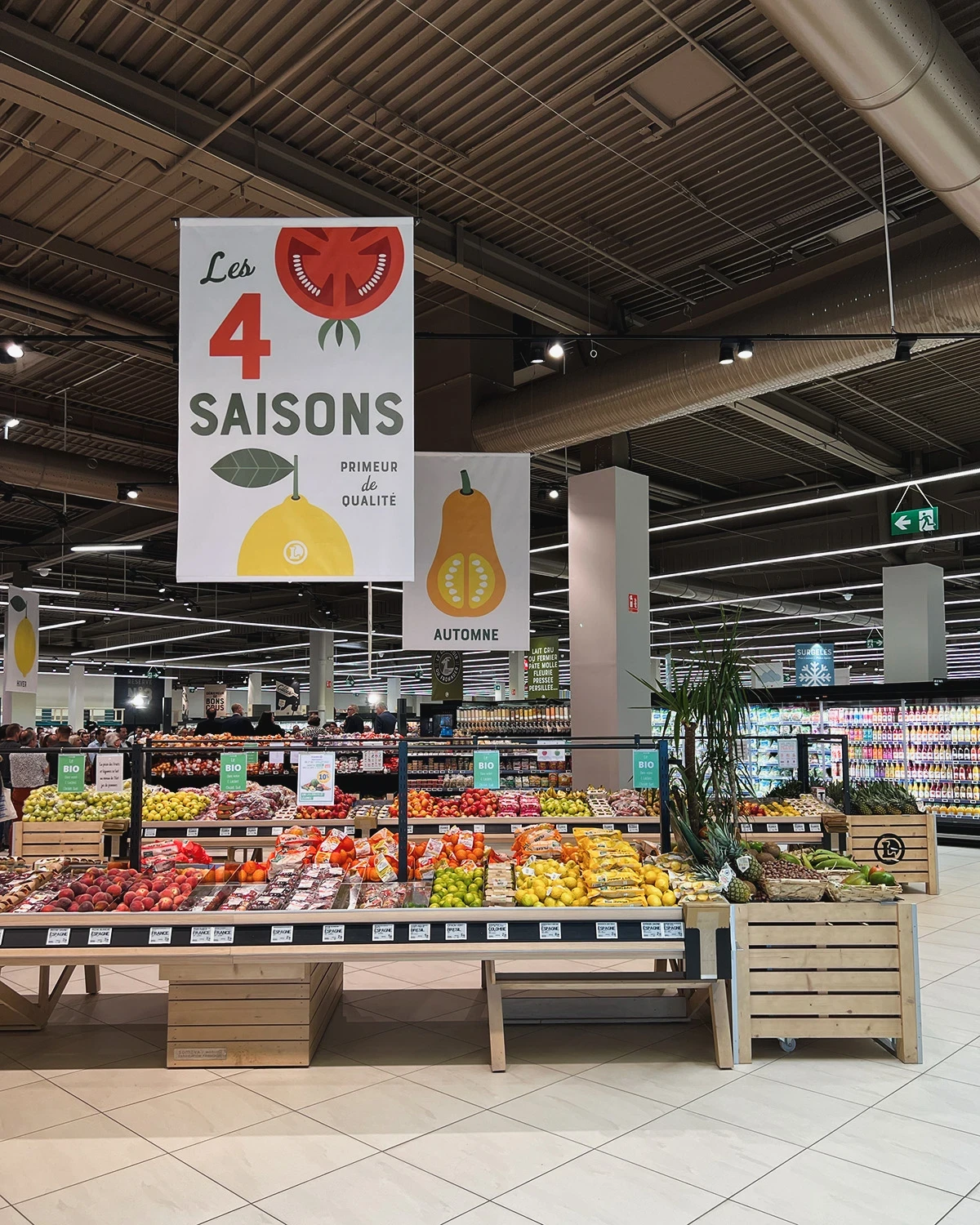 Graphisme et signalétique indiquant les produits dans le rayon fruits et légumes d’un hypermarché.
