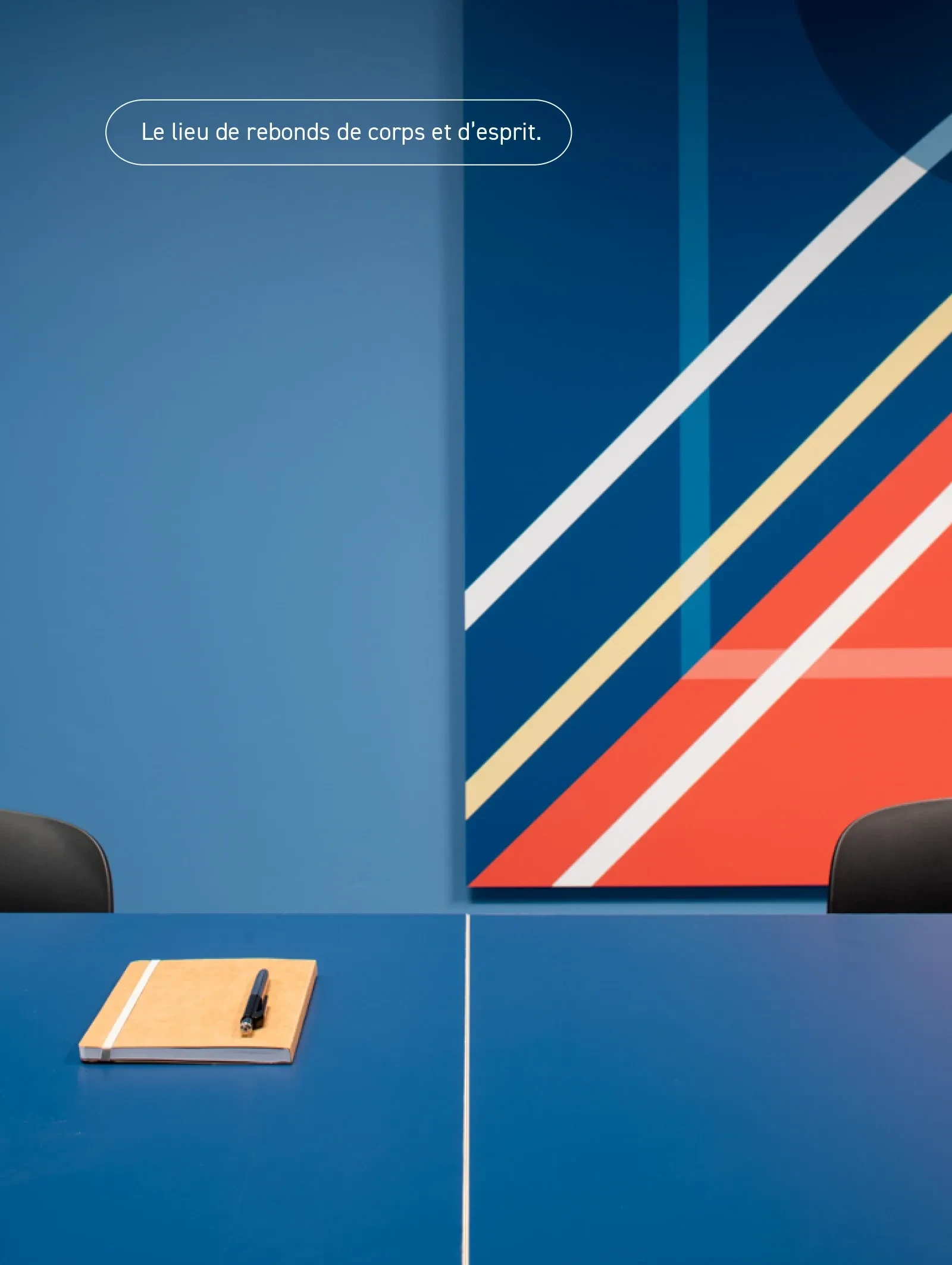 zoom sur un bureau avec un carnet et une fresque géométrique